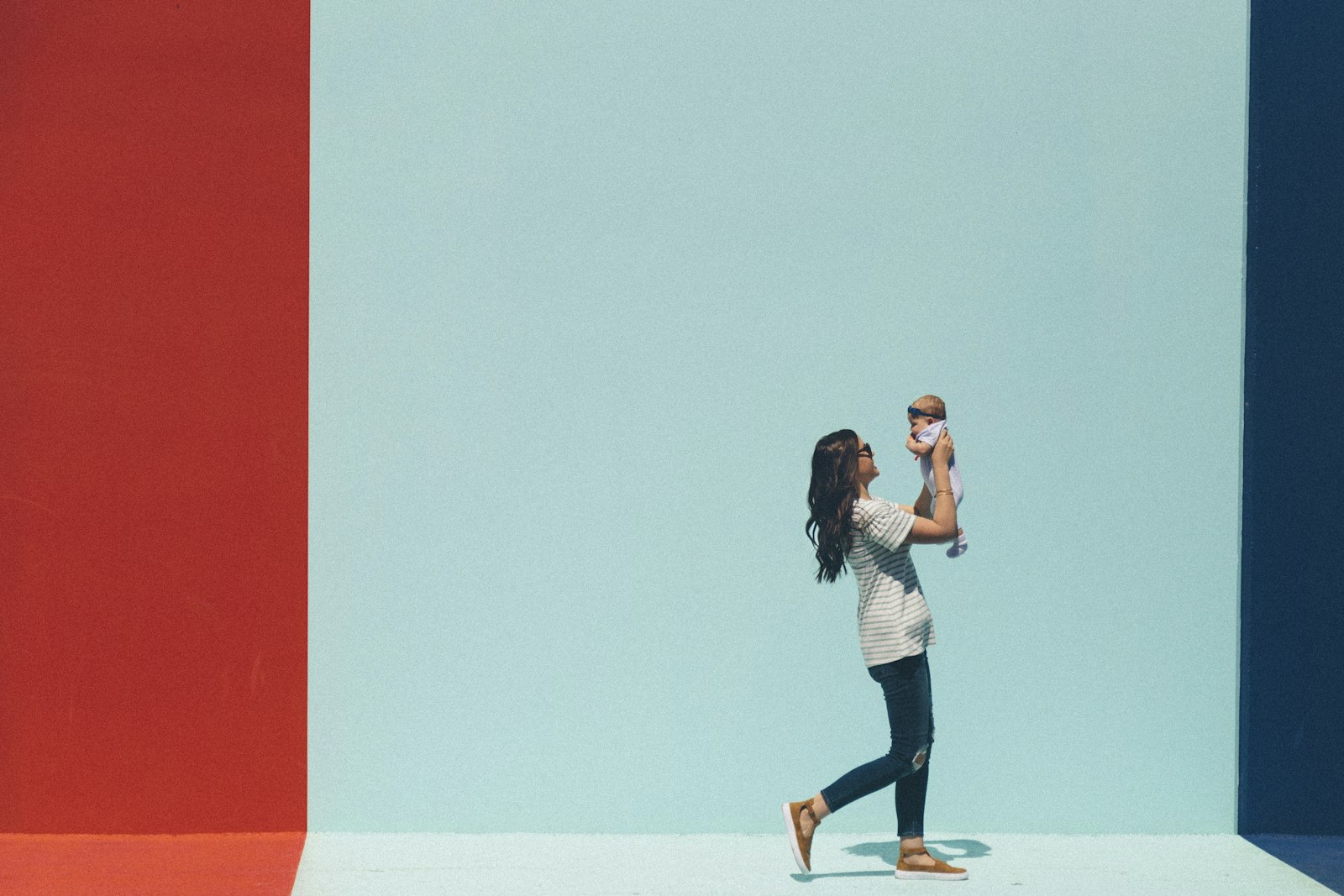 Fizjoterapia po porodzie — mama podnosi niemowlę
